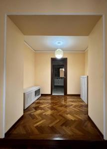 贝内文托Malies B&B的一间空房间,铺有木地板,设有走廊