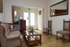 埃斯基维亚斯杜尔西内亚旅馆的客厅配有两把椅子、一张桌子和镜子