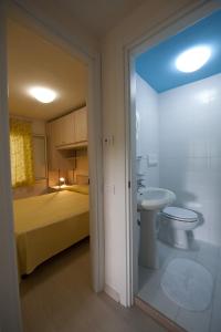 维耶斯泰Residence Le Orchidee的浴室设有床、卫生间和水槽。