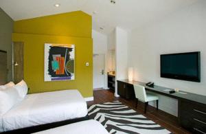 基韦斯特杜鲁门酒店的一间卧室配有一张床、一张书桌和一台电视。