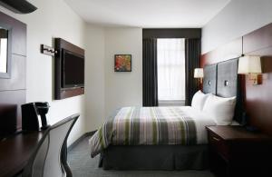 休斯顿Club Quarters Hotel Downton, Houston的酒店客房,配有床和电视