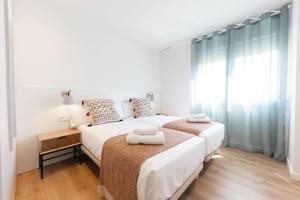 赫罗纳Bravissimo Falcó, 3 bedrooms and balcony的白色卧室设有两张床,配有窗户