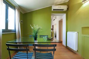 米兰Contempora Apartments - Fiori Chiari 26的一间拥有绿色墙壁和玻璃桌椅的用餐室