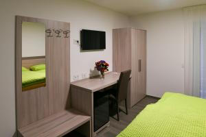 CamaMotel Afia的一间卧室配有书桌和一张带镜子的床