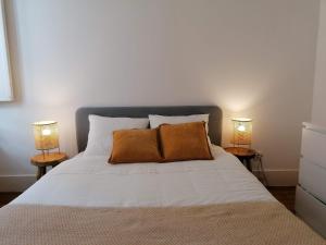 里斯本Stunning Apartment Marquês de Pombal的卧室配有带两盏灯的白色床