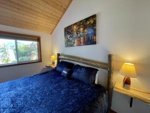 尤克卢利特Beautiful Oceanfront Cabin With Hot Tub! - Gone With The Wind的一间卧室设有蓝色的床和窗户。