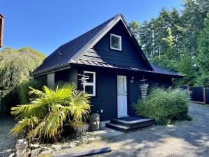 尤克卢利特Beautiful Oceanfront Cabin With Hot Tub! - Gone With The Wind的一间黑色的小房子,有白色的门