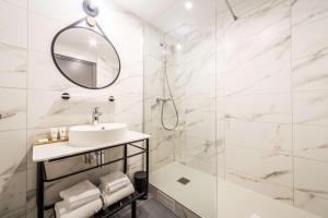 韦尔蒂Best Western Le Relais du Vigneron的白色的浴室设有水槽和淋浴。