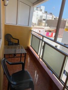 阿罗纳Pensión La Paloma的一间设有两把椅子、一张桌子和一个窗户的房间
