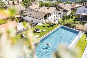 马莱斯韦诺斯塔白十字酒店的在房子里游泳池游泳的人
