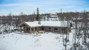 FlatåkerNEW LUXUARY Cabin with perfect location on Geilo.的雪中的房子,屋顶上积雪