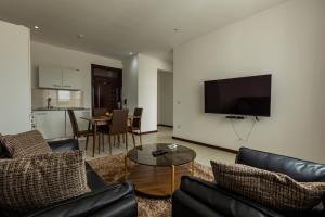 阿克拉Accra Fine Suites - Henrietta's Residences的客厅配有沙发和墙上的电视