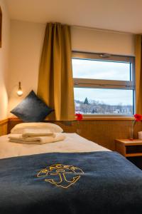 布拉格博特尔酒店的一间卧室设有一张大床和大窗户