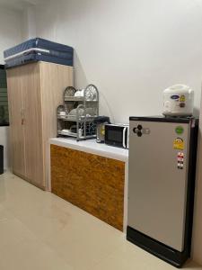 合艾Khoksametchun Hostel Plus 2的厨房配有冰箱,位于柜台旁