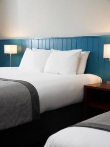 邓斯特布尔海维曼酒店的卧室配有带白色枕头的大床