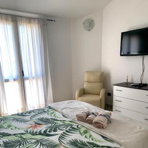 MaracalagonisVilla Maria的一间卧室配有一张床、一把椅子和电视