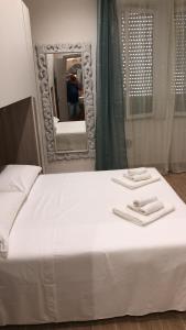 皮昂比诺Antico Hotel Moderno的一张带镜子和两条毛巾的床