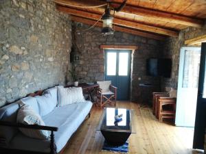 伊罗达Pappou's Traditional Cottage at Epano Elounda的客厅设有蓝色的沙发和石墙