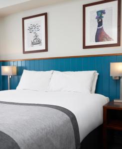 邓斯特布尔海维曼酒店的一张位于酒店客房的床铺,墙上挂有两张照片