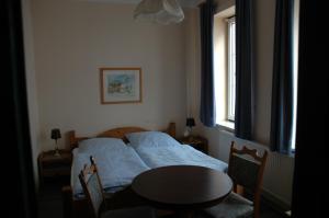 卡珀尔恩卡培尔纳霍夫酒店的一间卧室配有一张床、一张桌子和一个窗户。