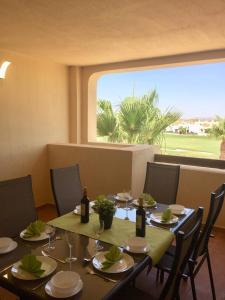 穆尔西亚Casa Moriarty的一间带桌椅和大窗户的用餐室