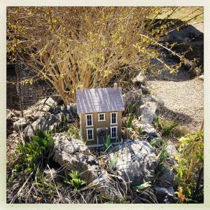格雷奥利埃Petit chalet pour amoureux de la nature au « Domaine de Tara »的一座小房子,坐在一些岩石上
