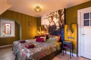 布雷达Bed & Breakfast - Gallery 't Speelhuys的卧室配有一张床,墙上挂有绘画作品