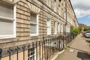 爱丁堡The Edinburgh Meadows Apartment的街道旁的一座带围栏的建筑