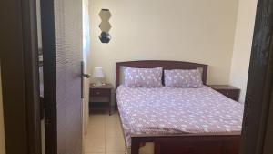 伊夫兰Appartement ifrane的小卧室配有一张带紫色床单和枕头的床