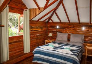 维奥康德马奥Chale Canto dos Cristais的卧室配有一张床铺,位于带木墙的房间内