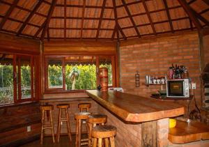 维奥康德马奥Chale Canto dos Cristais的小屋内的厨房设有酒吧和凳子