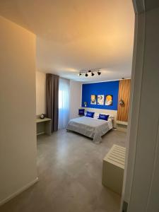 维耶斯泰La Corte del Sole的一间卧室设有一张床和蓝色的墙壁