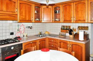 诺切劳恩布拉CASA VALENTINA的厨房配有木制橱柜、水槽和桌子