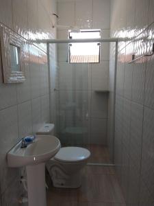 卡拉瓜塔图巴Recanto Jubarte (Massaguaçu Caraguatatuba - SP)的白色的浴室设有卫生间和水槽。
