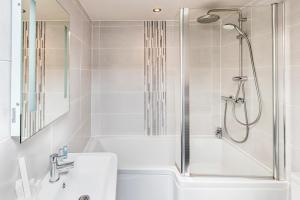 斯基普顿长毛羊宾馆的白色的浴室设有淋浴、浴缸和水槽。