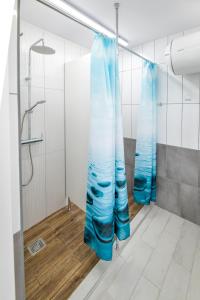 扎托尔KempingZator Namioty的浴室内配有蓝色窗帘的淋浴