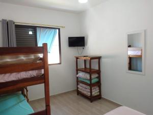 卡拉瓜塔图巴Recanto Jubarte (Massaguaçu Caraguatatuba - SP)的客房设有双层床和电视。