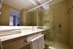 埃斯特城Rio Hotel by Bourbon Ciudad Del Este的带淋浴、盥洗盆和镜子的浴室