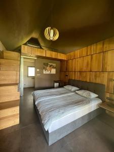 特尔日奇Ranč Mackadam Ranch Mackadam的一间卧室设有一张带木墙的大床