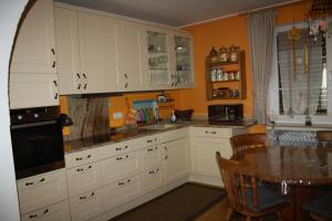 本多夫Ferienhaus Lilli的厨房配有白色橱柜和桌子