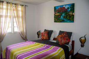勒穆莱Villa Prunepassion的卧室配有一张床,墙上挂有绘画作品