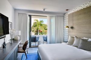 迈阿密海滩Kaskades Hotel South Beach的酒店客房设有一张大床和一个阳台。