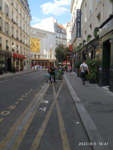 巴黎Hotel Geoffroy Marie Opéra的一条空荡荡荡的城市街道,人们沿着街道走