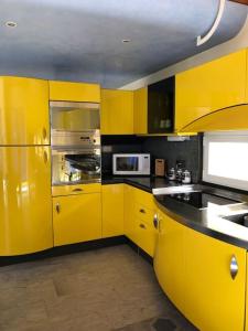 MalvagliaBluVilla的黄色的厨房,配有黄色橱柜和水槽