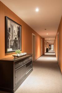 蒂伦豪特Turnhout City Hotel的走廊上设有橙色墙壁和墙上的大画