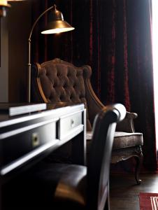 戈赖斯Hotel Castillo de Gorraiz&Spa的一间带椅子、桌子和灯的房间