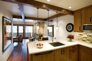 阿斯潘Luxury 1 Bedroom Downtown Aspen Vacation Rental With Access To A Heated Pool, Hot Tubs, Game Room And Spa的一个带水槽的厨房和一间客厅