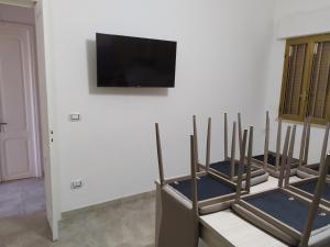 托雷拉皮罗VILLA AURORA 2的客房设有3把木椅和平面电视。
