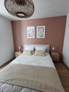 贝莱姆L'Ilot du Perche: Appartement cosy avec jardin的一间卧室配有一张大床和一个吊灯。