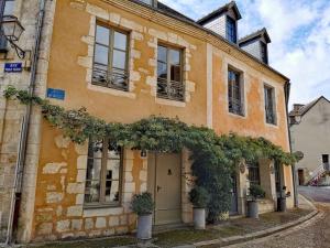 贝莱姆L'Ilot du Perche: Appartement cosy avec jardin的一座橘色的建筑,前面有植物